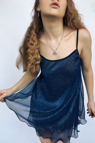Синя напівпрозора сукня зі струмливої сіточки бренду NANIKA, вигляд на моделі спереду з легкою накидкою.
