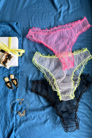 Набір прозорих сітчастих трусиків NANIKA – flat lay зйомка. Рожеві, білі з неоновою окантовкою та чорні мереживні трусики з рюшами, легка прозора mesh-тканина, мінімалістичний крій, жіночна та сексуальна білизна.