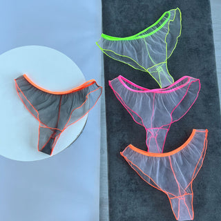 Кольорові прозорі жіночі трусики з сіточки - бренд NANIKA, білизна лежить на фоні